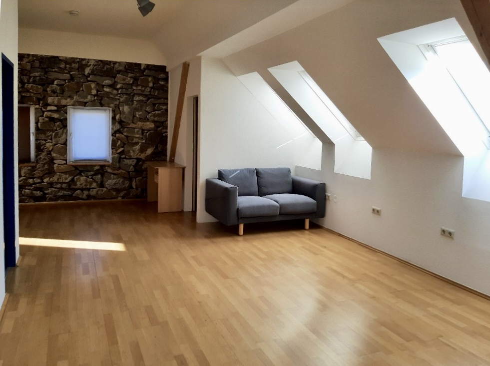 Dachgeschoss-Wohnung mit Naturstein-Akzentwand und Dachfenstern